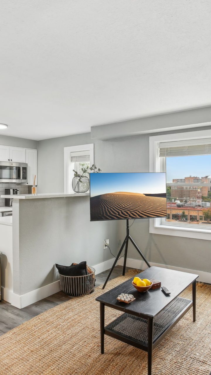 a living room with a couch, coffee table and television at The Broadway 46 Apartments